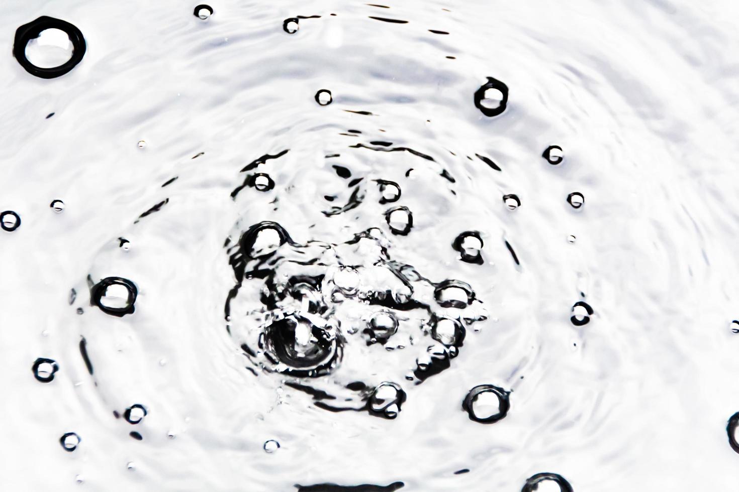 Water droplets or water beads fall on the water surface causing the water surface to disperse and foam. photo