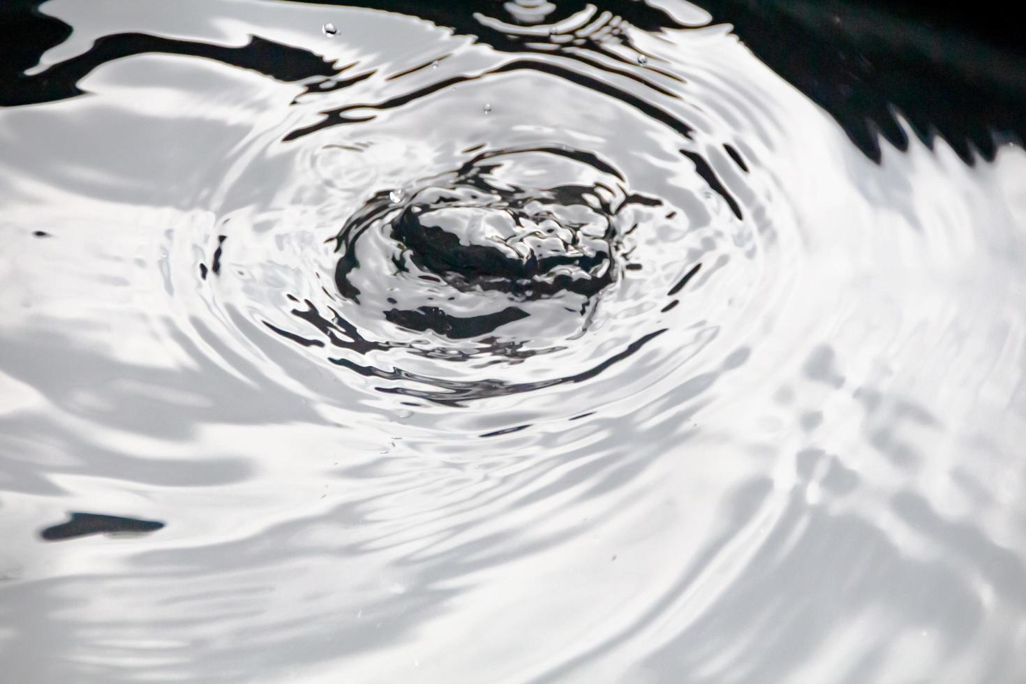 Water droplets or water beads fall on the water surface causing the water surface to disperse and foam. photo