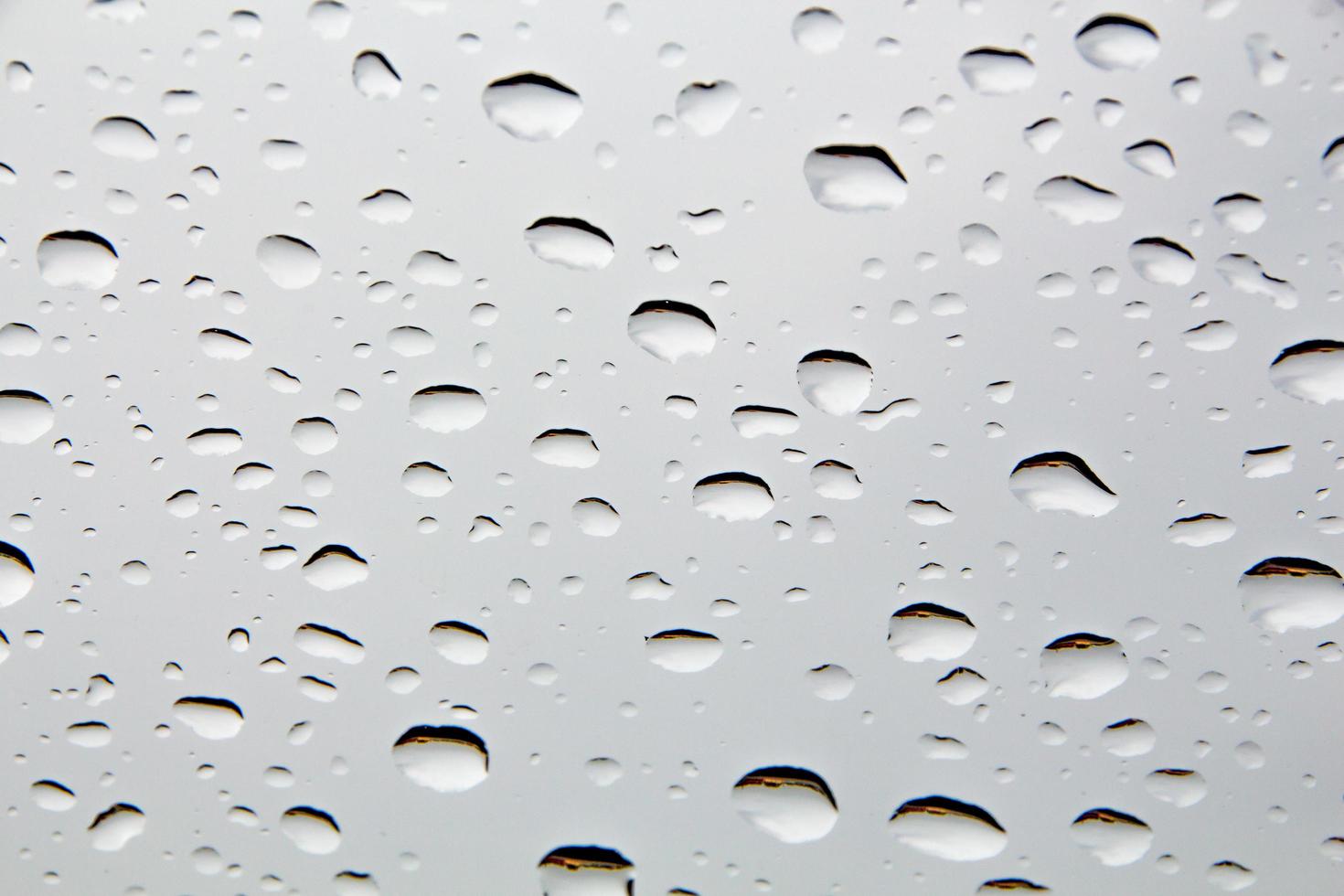 Drops of water and water beads on clear glass. photo