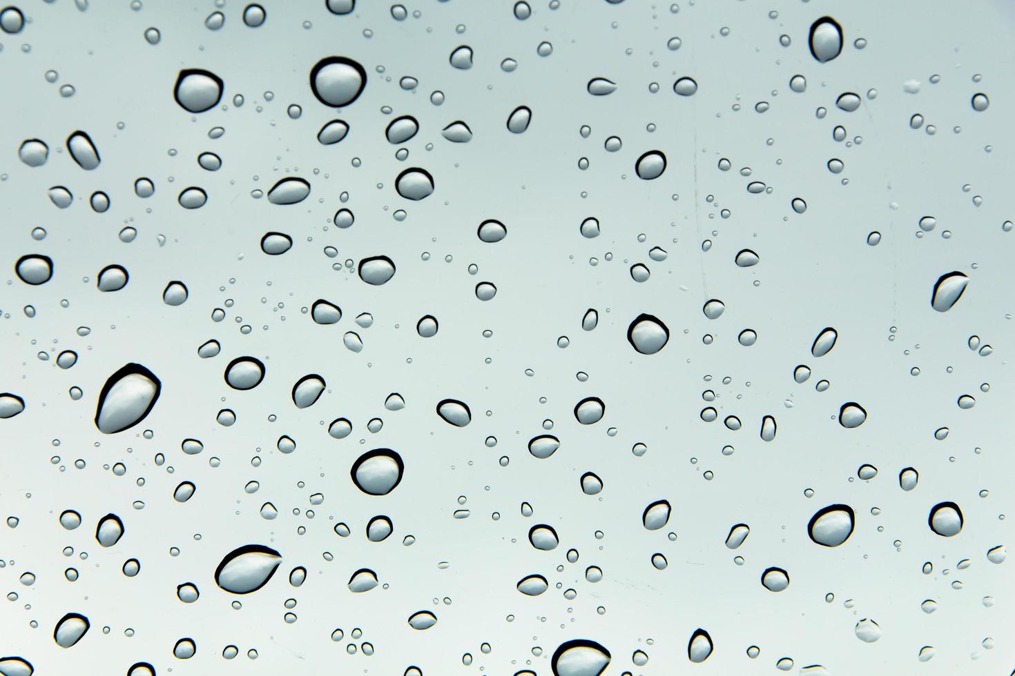 Drops of water and water beads on clear glass. photo