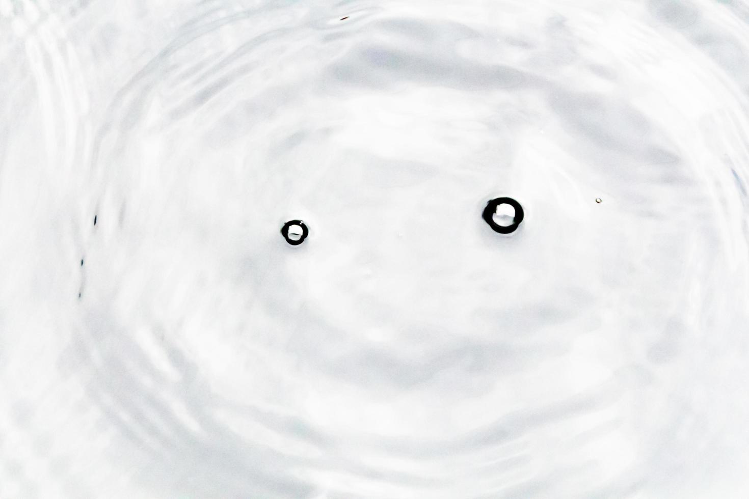 Water droplets or water beads fall on the water surface causing the water surface to disperse and foam. photo