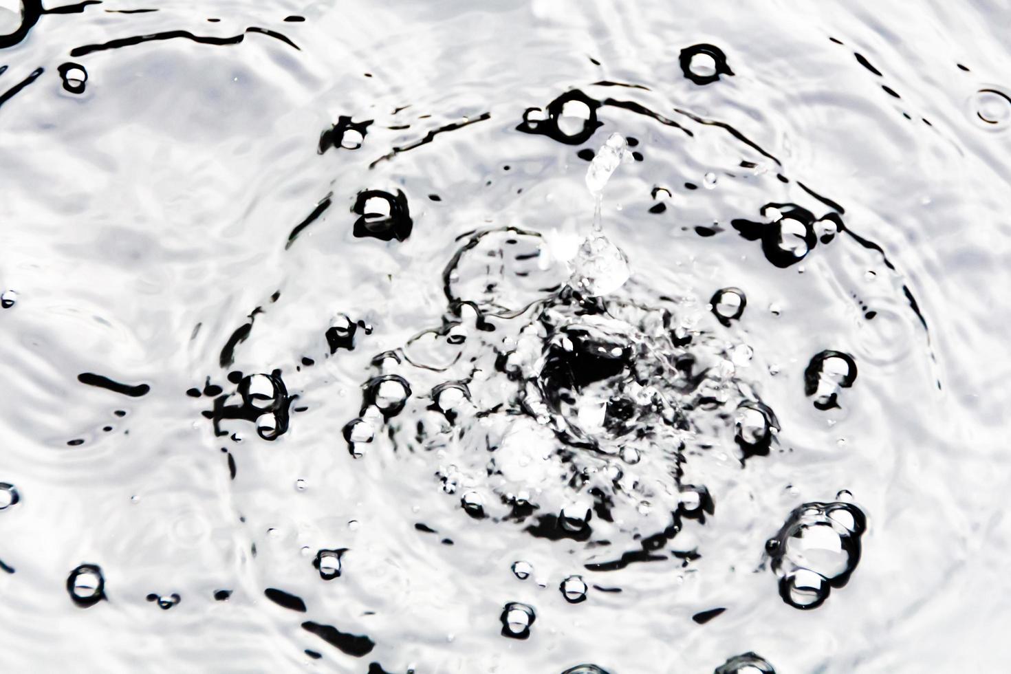 gotitas de agua o gotas de agua caen sobre la superficie del agua causando que la superficie del agua se disperse y forme espuma. foto