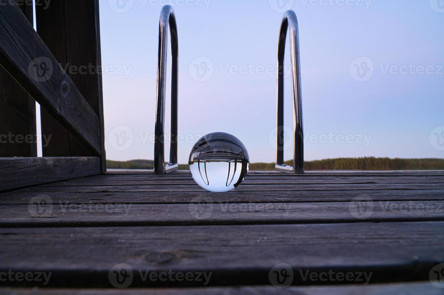 bola de cristal en un muelle de madera en un lago sueco a la hora de la tarde. naturaleza escandinavia foto