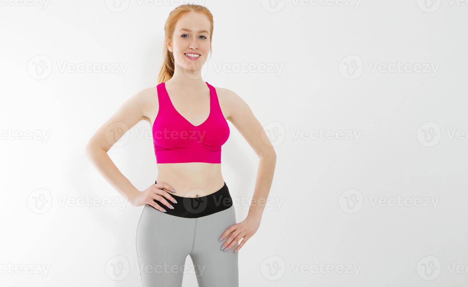 Young red haired girl in sport wear clothes isolated on white background. Slim body figure and healthy lifestyle. Fitness and sports concept. Banner photo