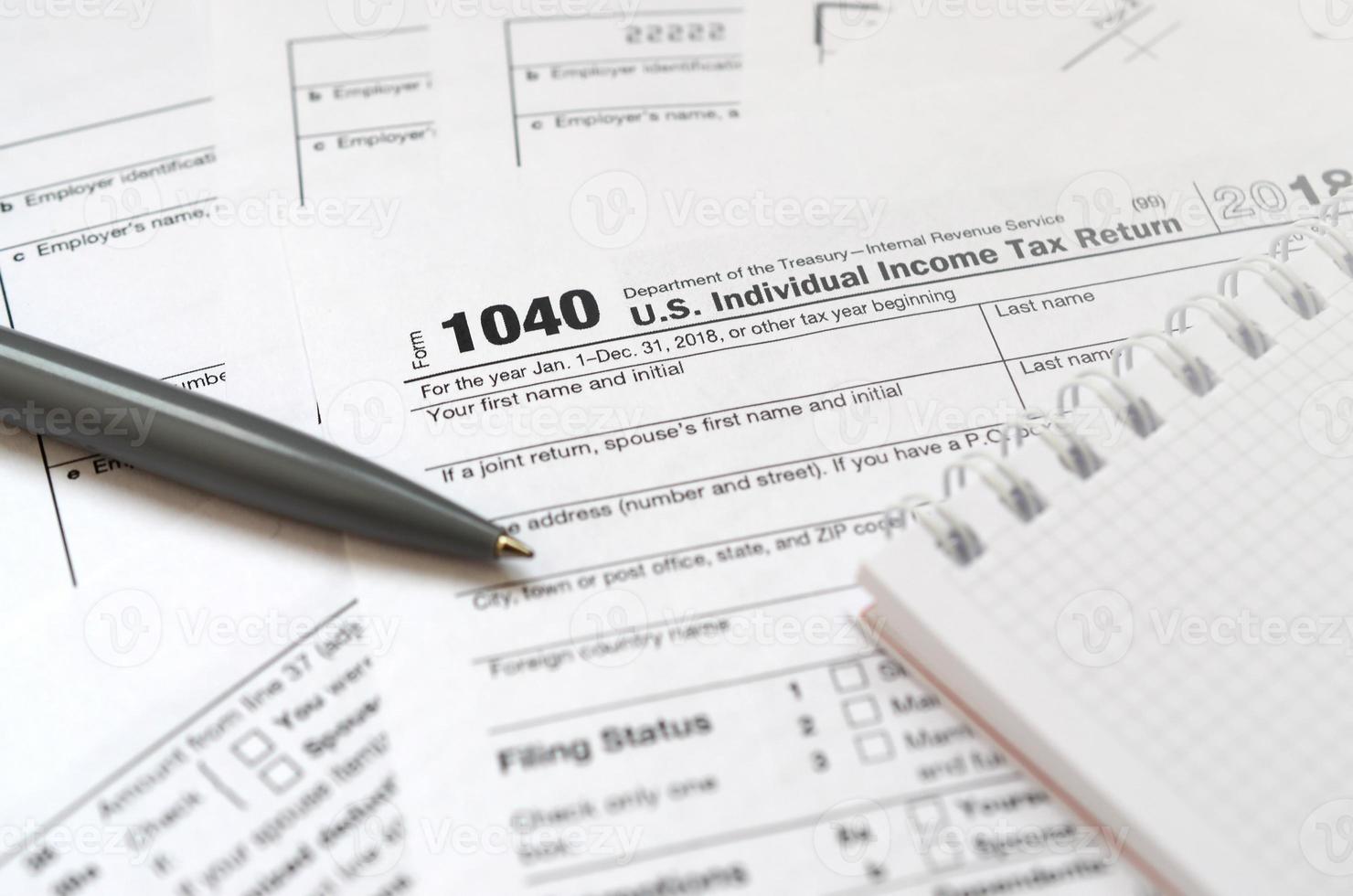 el bolígrafo y el cuaderno se encuentran en el formulario de impuestos 1040 us declaración de impuestos sobre la renta individual. la hora de pagar impuestos foto