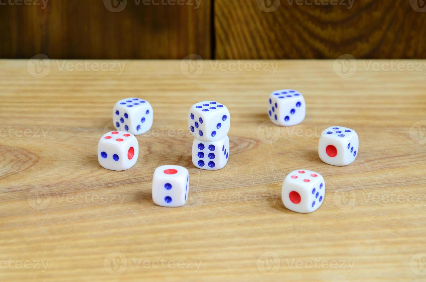 A few dice lies on the surface of natural wood. Items for generating numbers from one to six in the form of points that are painted on the side of cubes. The concept of gambling photo