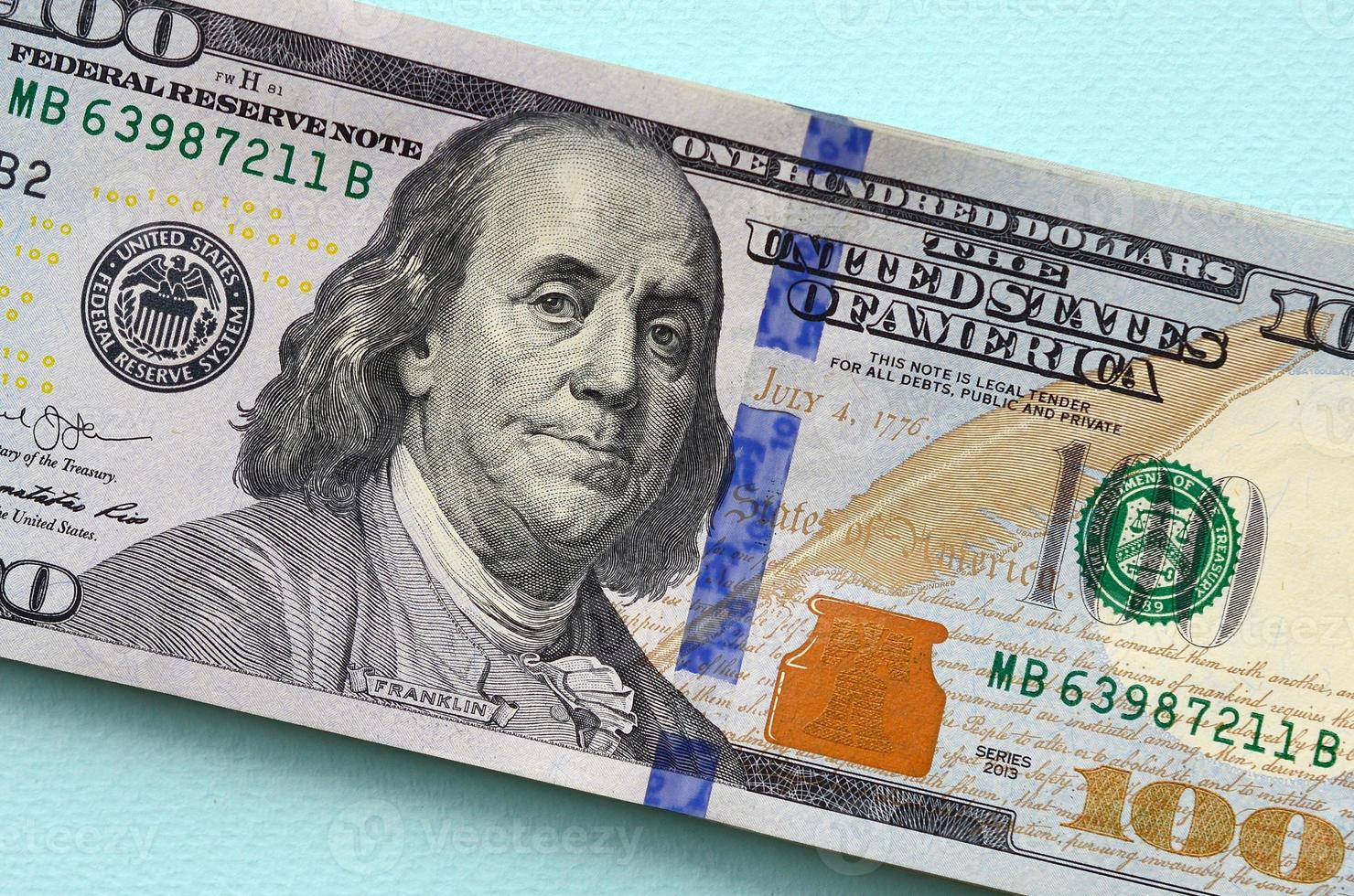 US dollar bills of a new design with a blue stripe in the middle is lies on a light blue background photo