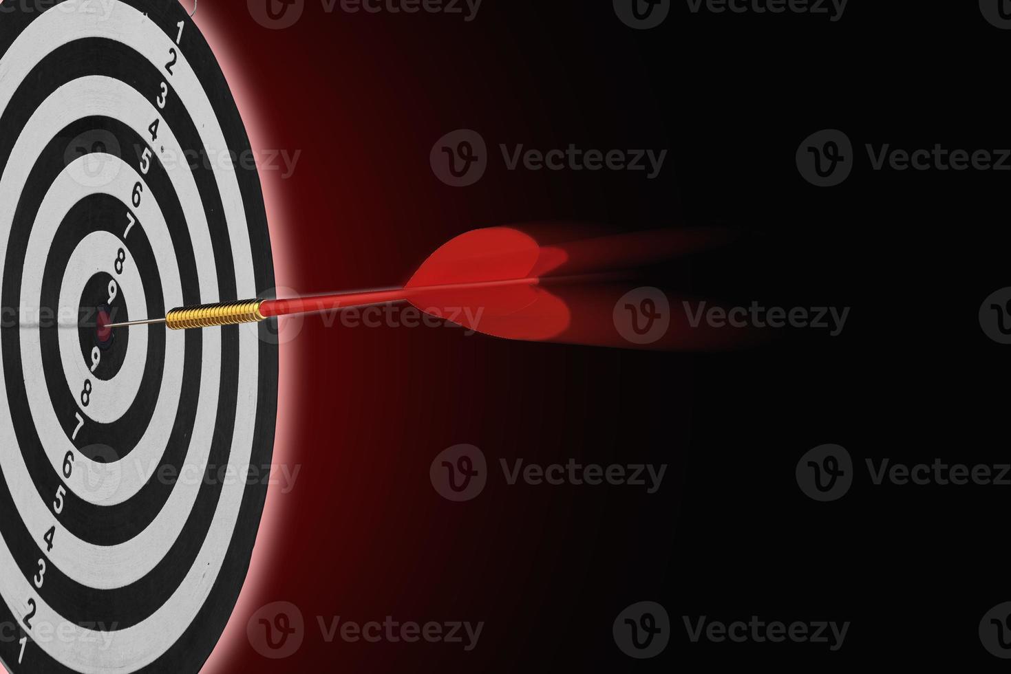one dart hit it's target on a red background, concept for success, photo