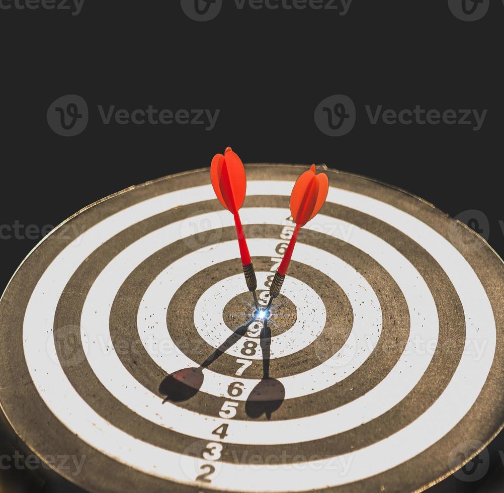 Two dart hit it's target on a red background, concept for success, photo