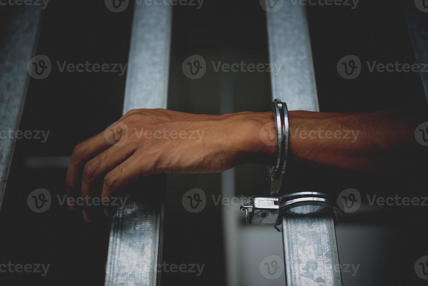 Hand of the prisoner on a steel lattice close up photo