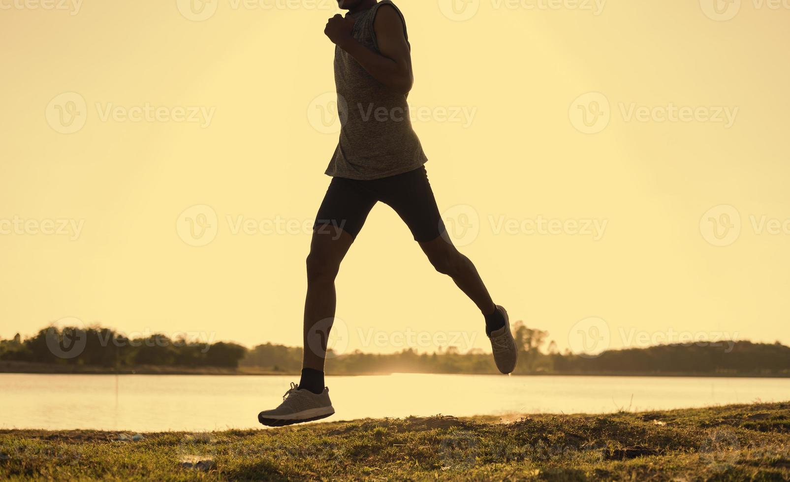 The silhouette of a man running is exercising the evening. photo
