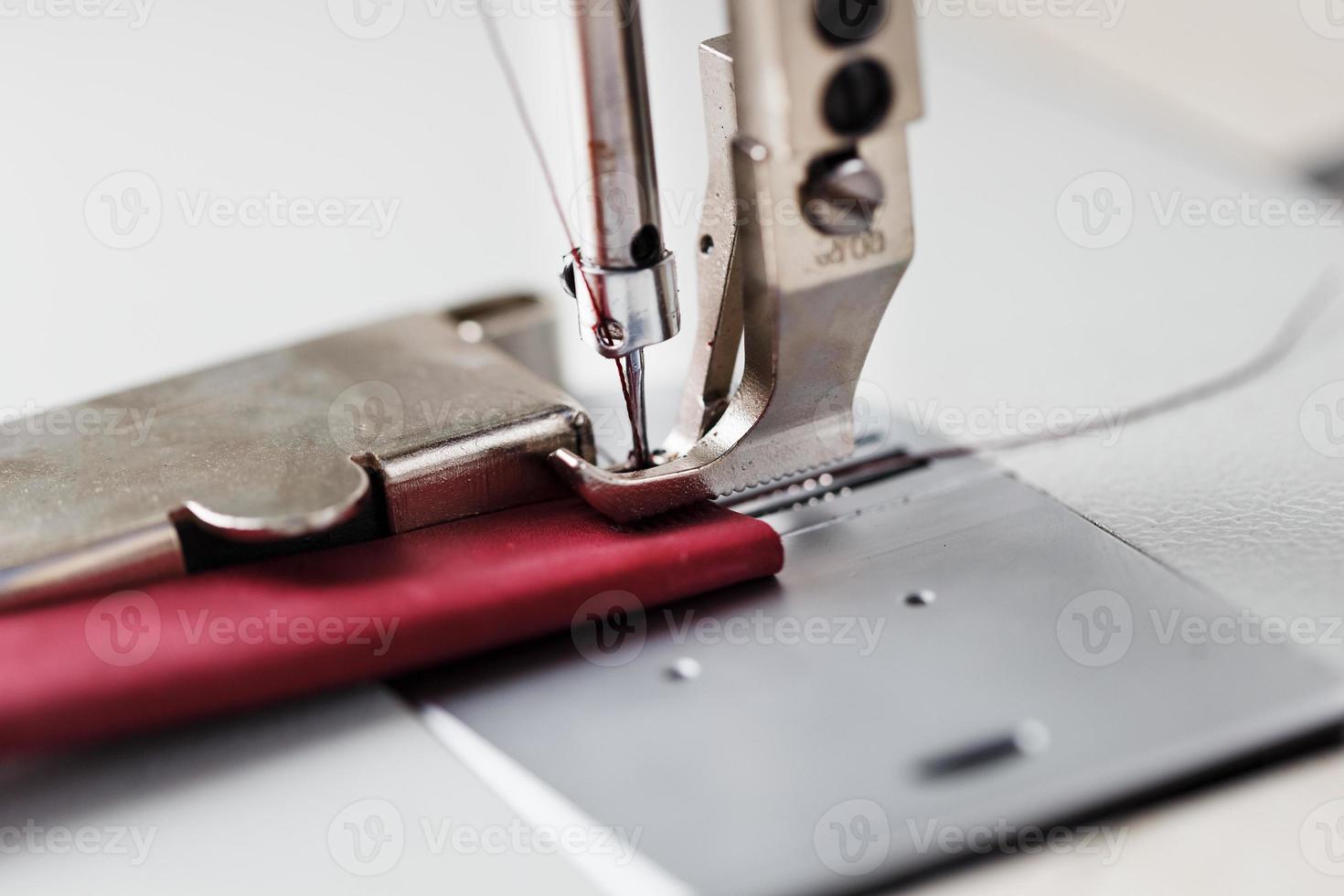 A leather craftsman produces leather goods on a sewing machine in his shop. photo