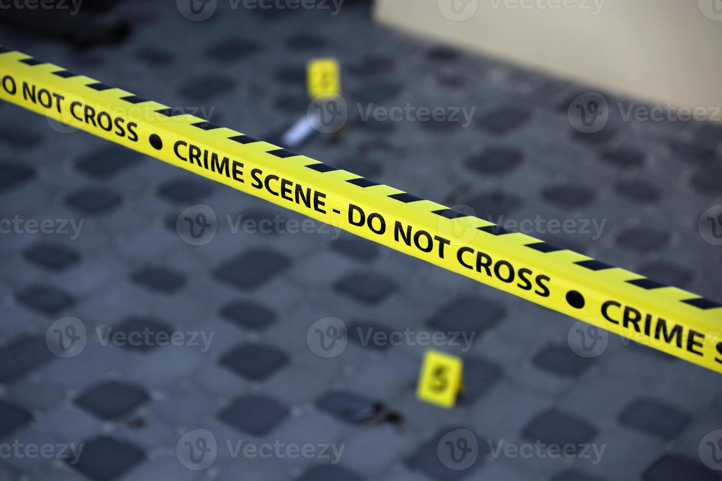 Crime scene tape for covering the area cordon. Yellow tape with blurred forensic law enforcement background in cinematic tone photo