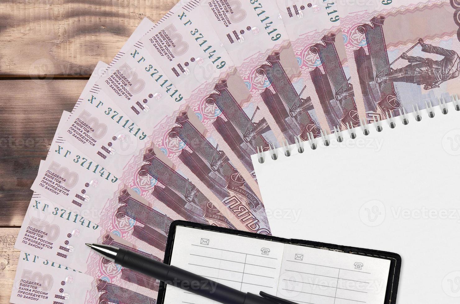 500 russian rubles bills fan and notepad with contact book and black pen. Concept of financial planning and business strategy photo