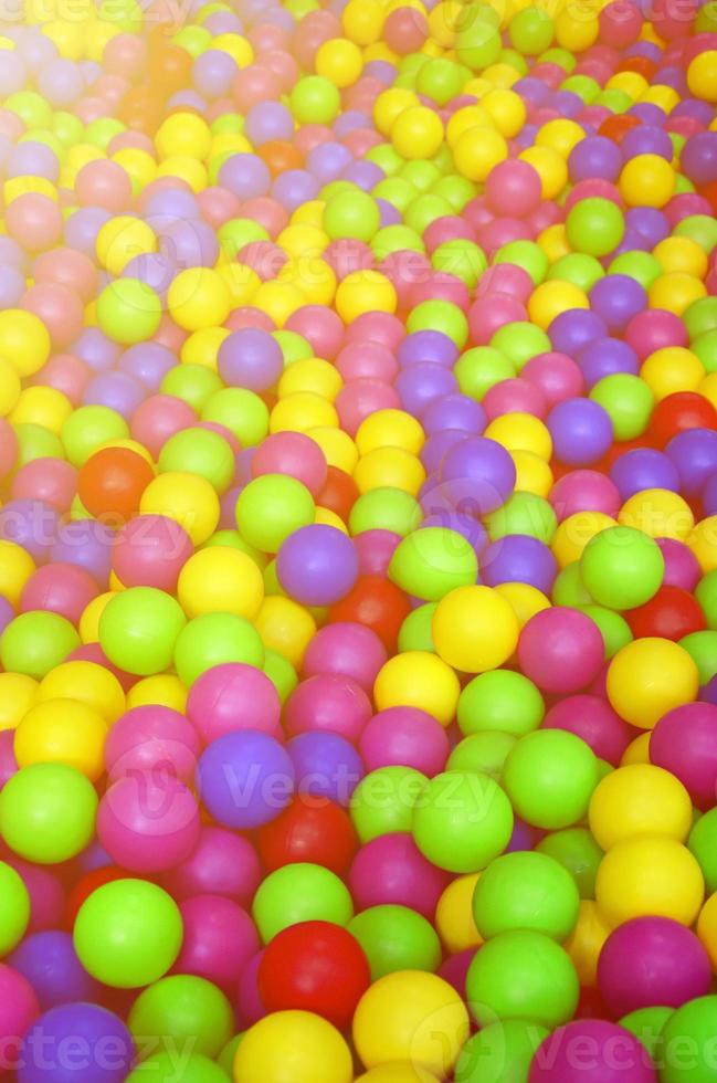 Many colorful plastic balls in a kids' ballpit at a playground. Close up pattern photo