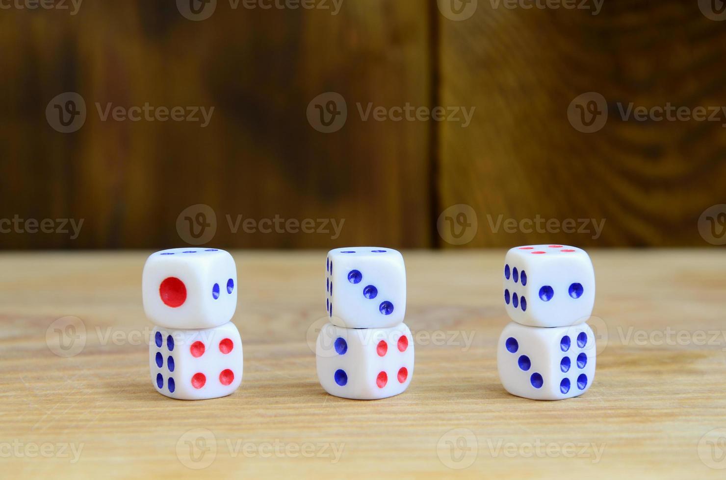 A few dice lies on the surface of natural wood. Items for generating numbers from one to six in the form of points that are painted on the side of cubes. The concept of gambling photo