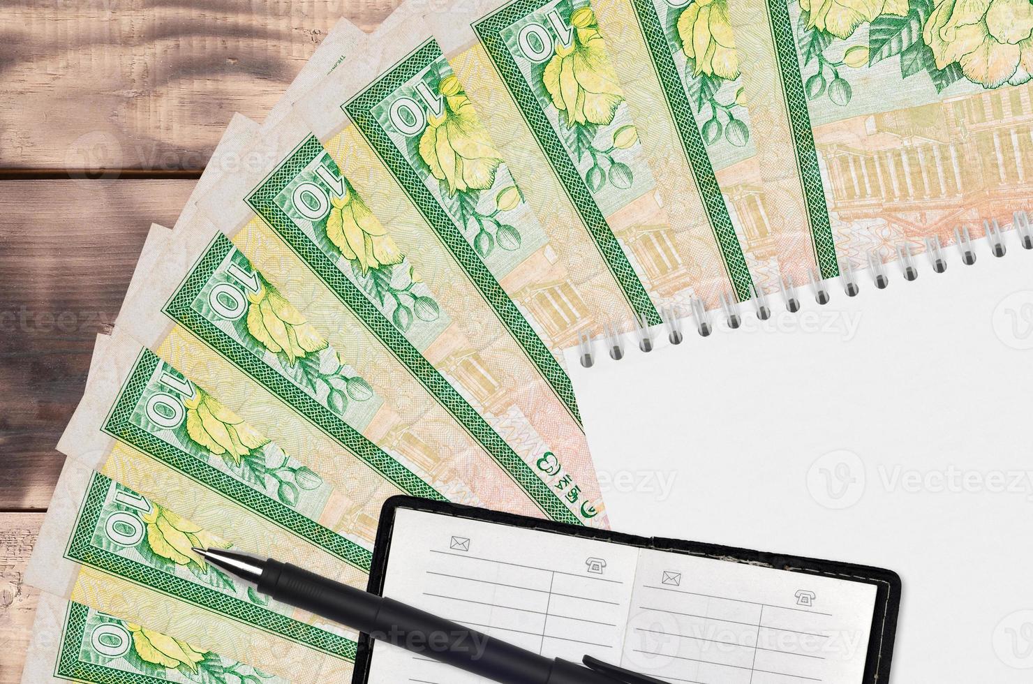 10 Sri Lankan rupees bills fan and notepad with contact book and black pen. Concept of financial planning and business strategy photo