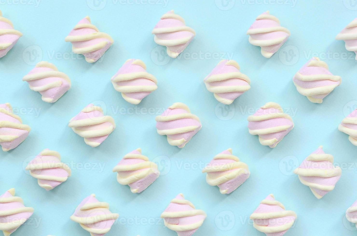 Colorful marshmallow laid out on blue paper background. pastel creative textured pattern. minimal photo