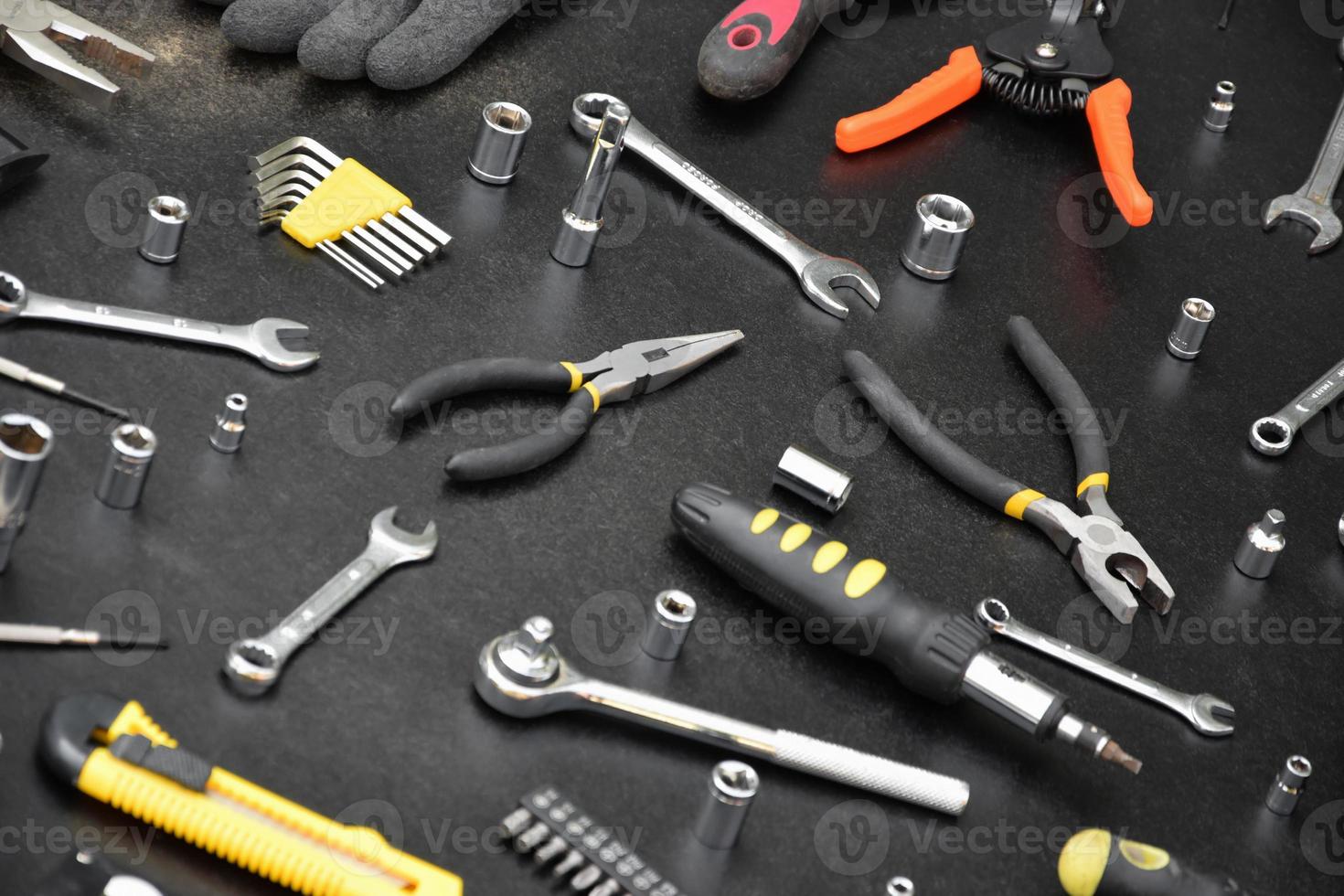 Handyman tool kit on black wooden table. Many wrenches and screwdrivers, pilers and other tools for any types of repair or construction works. Repairman tools photo