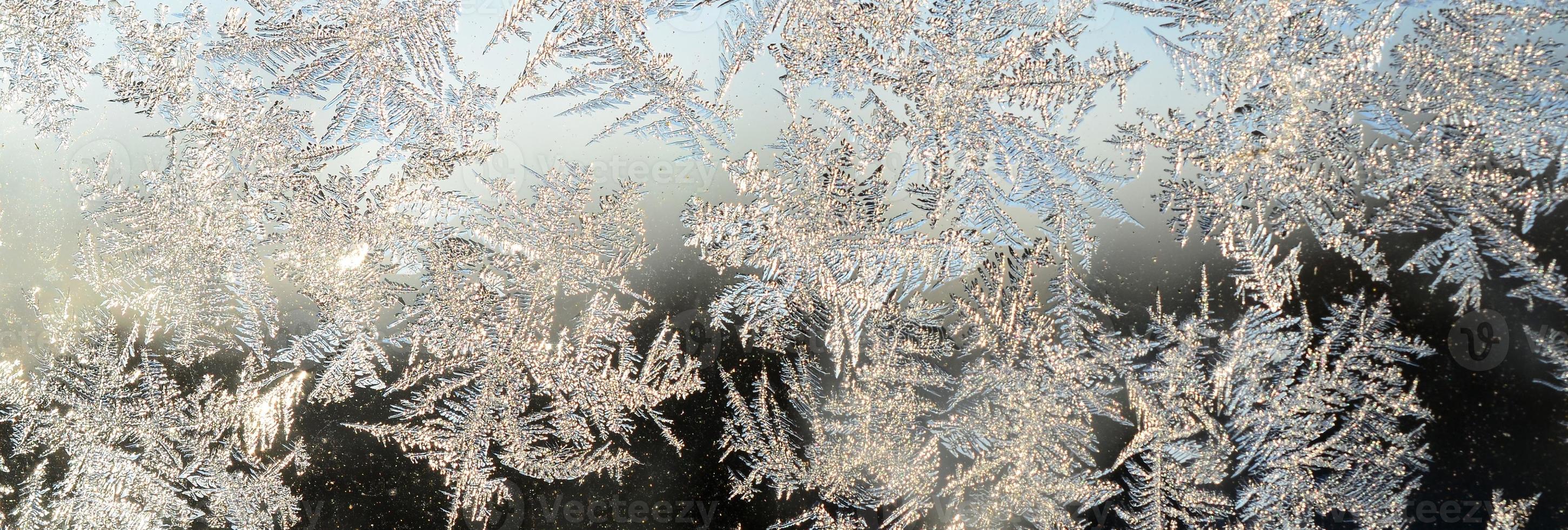 Snowflakes frost rime macro on window glass pane photo