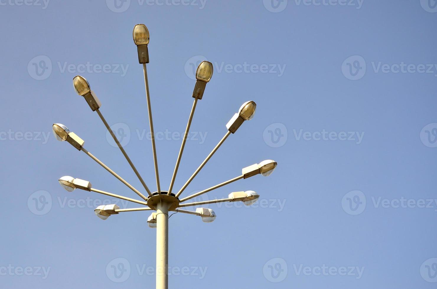 A street lamp consisting of a high pillar and a number of plafonds for light sources. Unusual view of street lighting in Ukraine photo