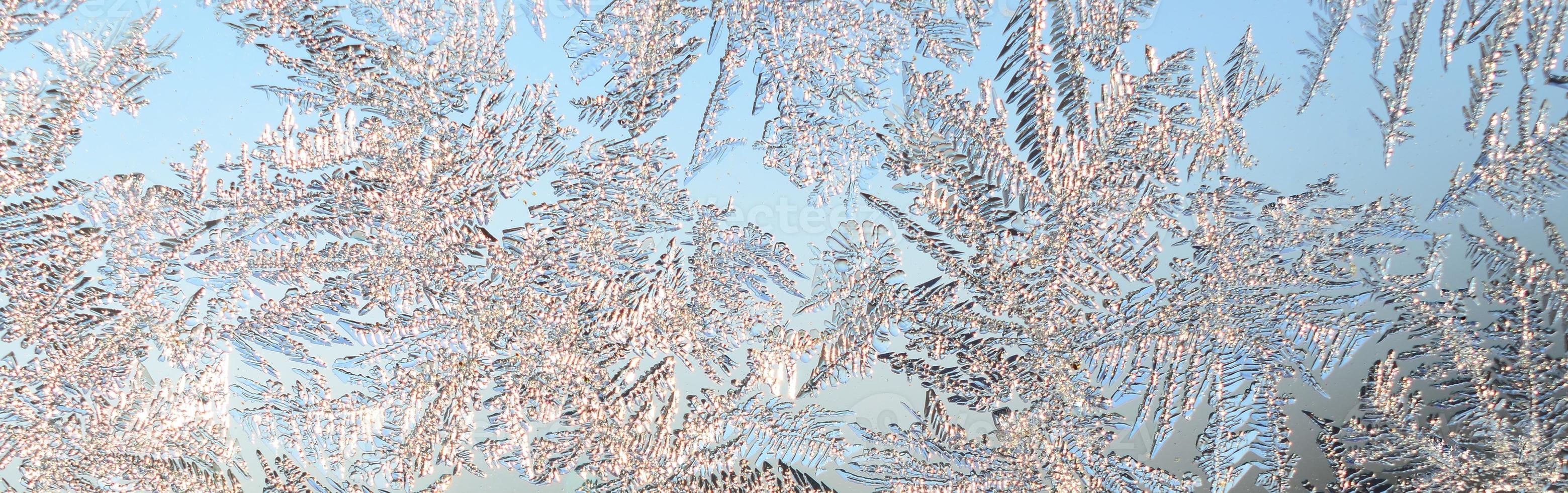 Snowflakes frost rime macro on window glass pane photo