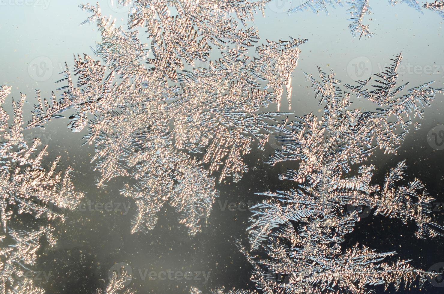 Snowflakes frost rime macro on window glass pane photo