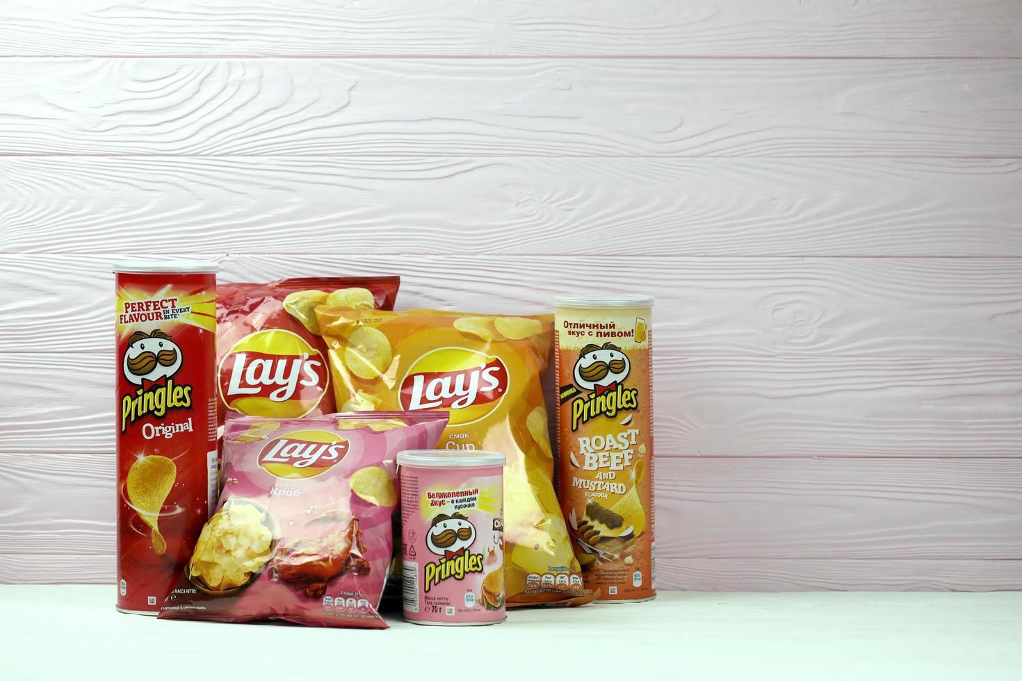 KHARKOV, UKRAINE - JANUARY 3, 2021 Various flavoured of lay's and pringles potato chips in classic packages design. Worldwide famous brands of potato chips photo