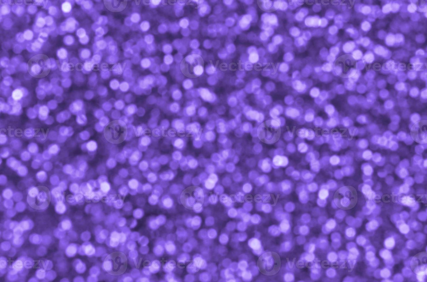 Blurred violet decorative sequins. Background image with shiny bokeh lights from small elements photo