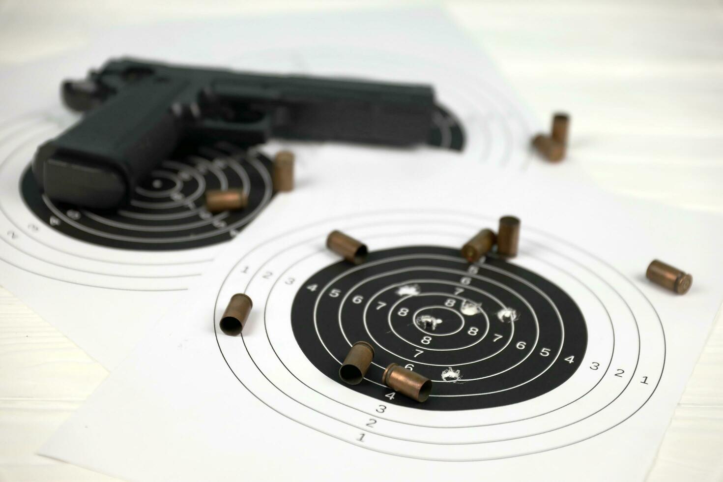 Gun and many bullets shooting targets on white table in shooting range polygon. Training for aiming and shooting photo