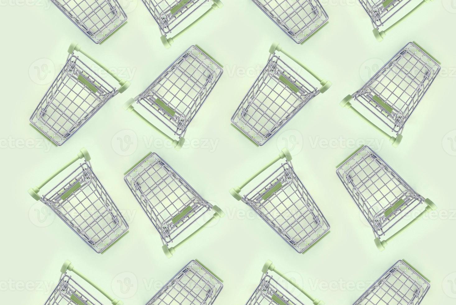 Pattern of many small shopping carts on a lime background photo