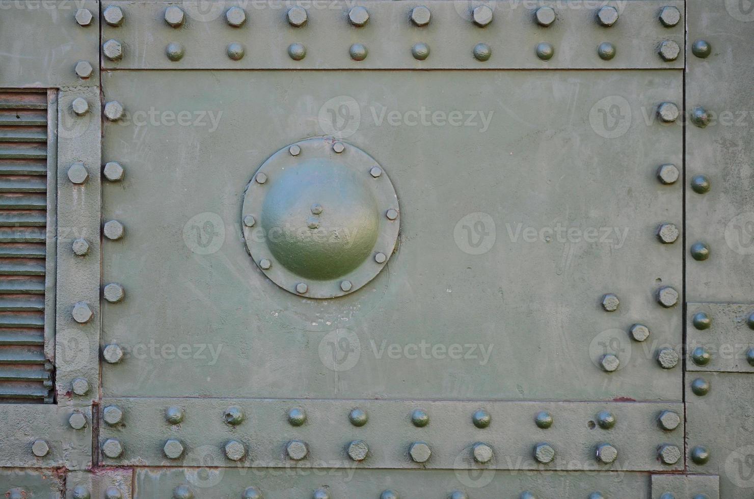 The texture of the wall of the tank, made of metal and reinforced with a multitude of bolts and rivets. Images of the covering of a combat vehicle from the Second World War photo