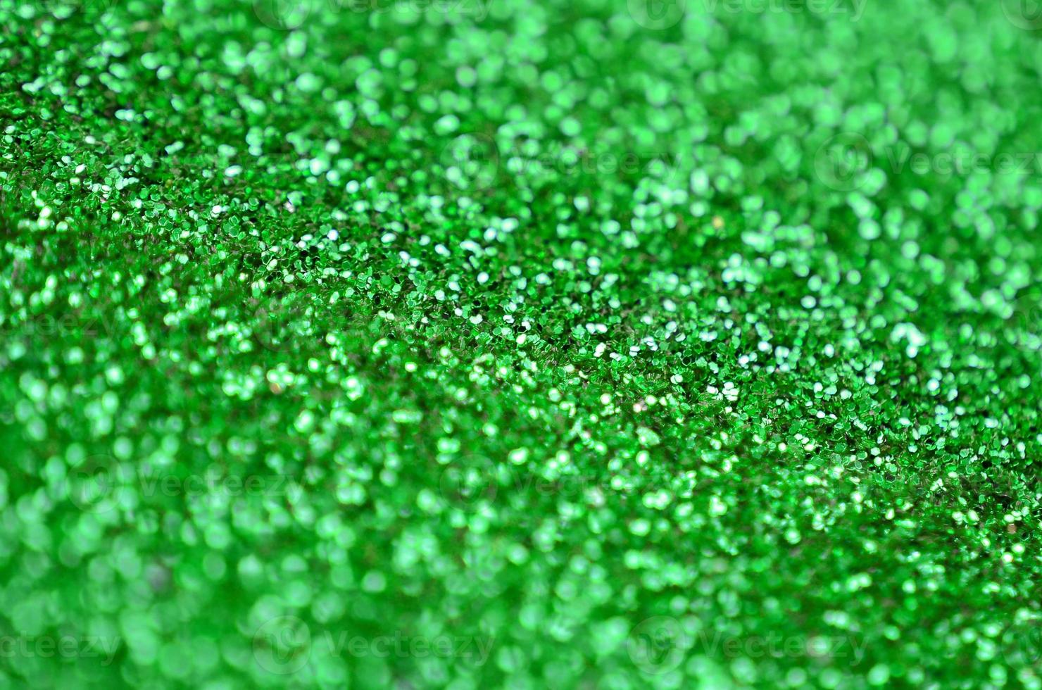 A huge amount of green decorative sequins. Background image with shiny bokeh lights from small elements photo