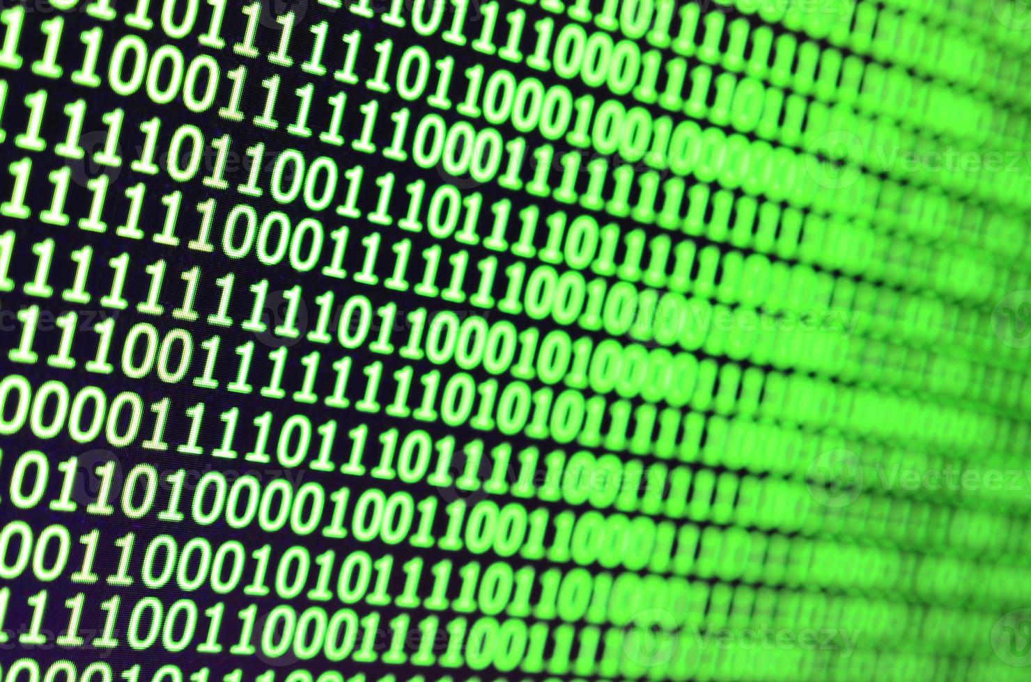 Macro shot of binary code on the monitor of an office computer. The concept of the programmer's work. The flow of digital information strings photo