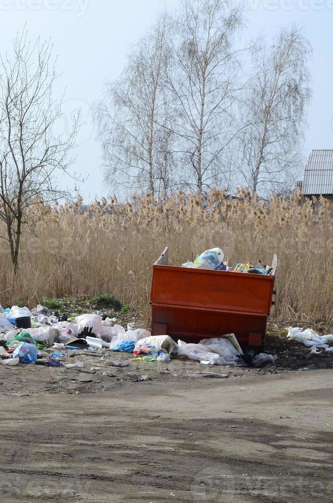 The garbage can is packed with garbage and waste. Untimely removal of garbage in populated areas photo