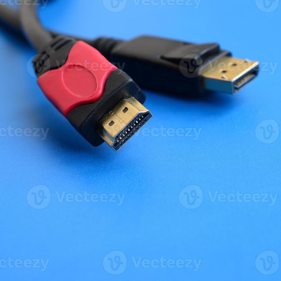 Audio video HDMI computer cable plug and 20-pin male DisplayPort gold plated connector for a flawless connection on a blue background photo