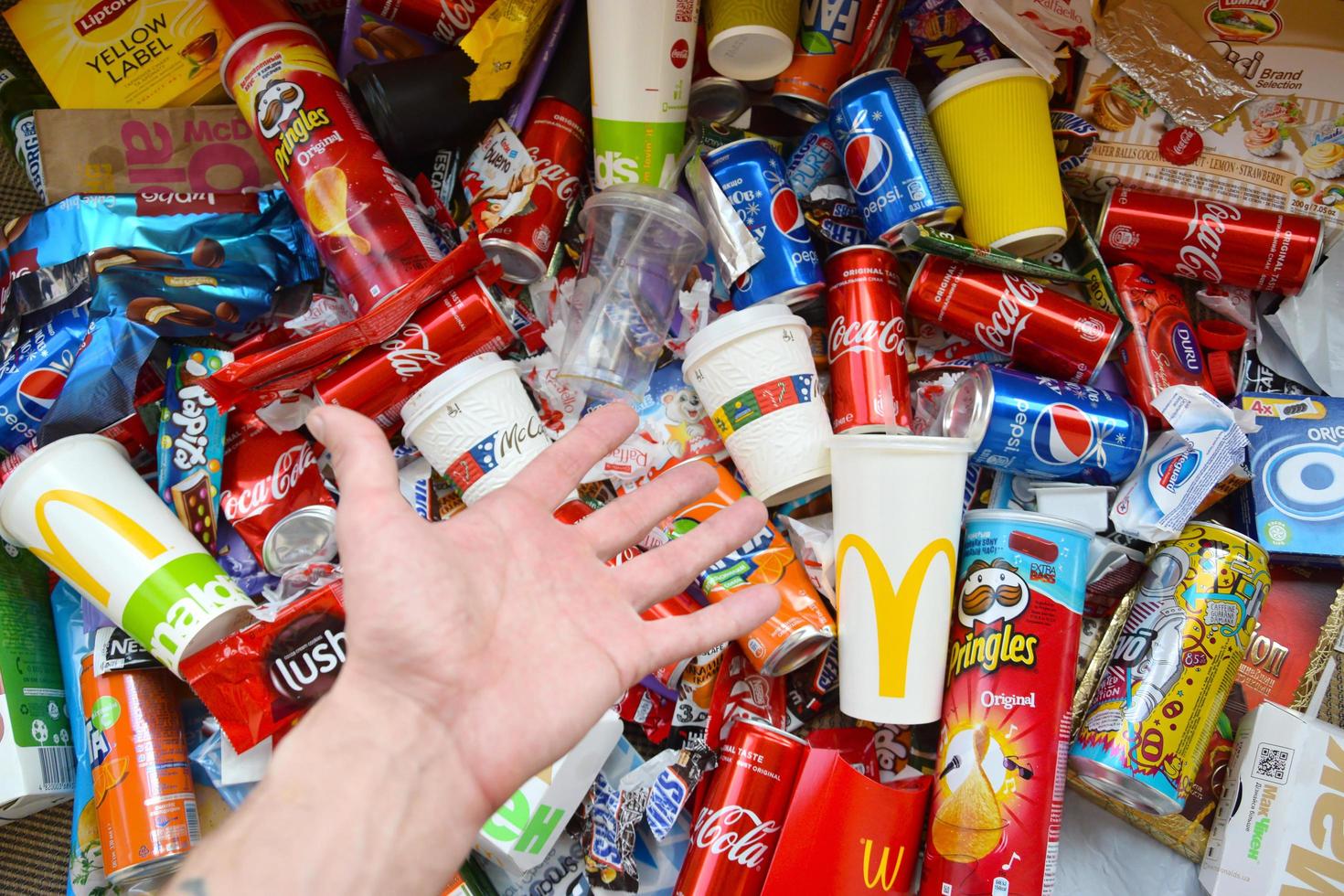 KHARKOV, UKRAINE - JULY 2, 2021 Many wrappings and cans from used products by famous worldwide brands. Pattern of trash of various colors and materials photo