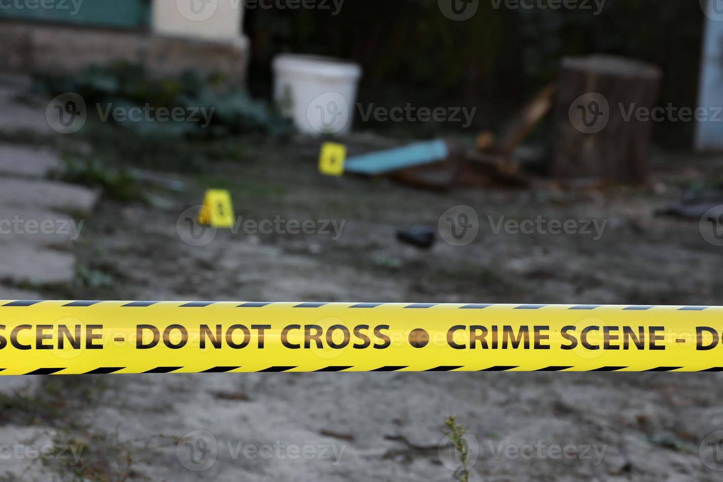 Crime scene tape for covering the area cordon. Yellow tape with blurred forensic law enforcement background in cinematic tone photo