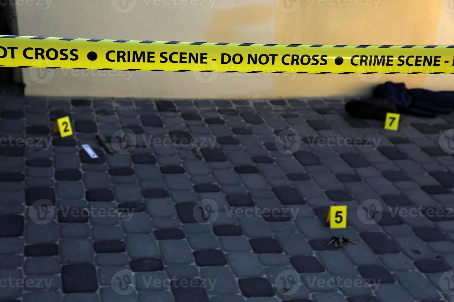 Crime scene tape for covering the area cordon. Yellow tape with blurred forensic law enforcement background in cinematic tone photo