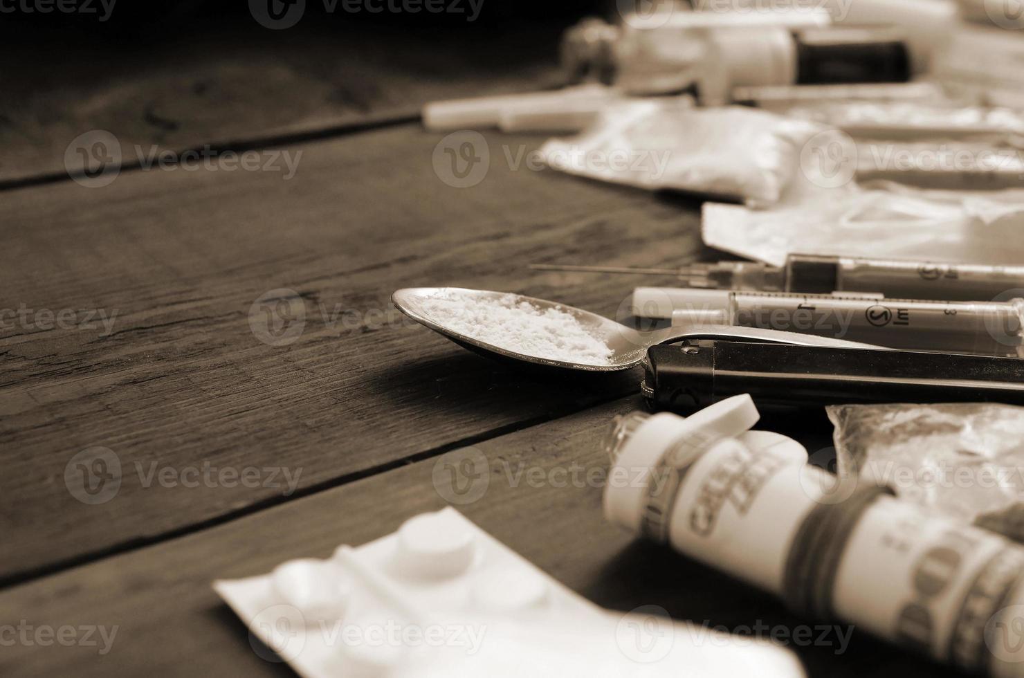 A lot of narcotic substances and devices for the preparation of drugs lie on an old wooden table photo