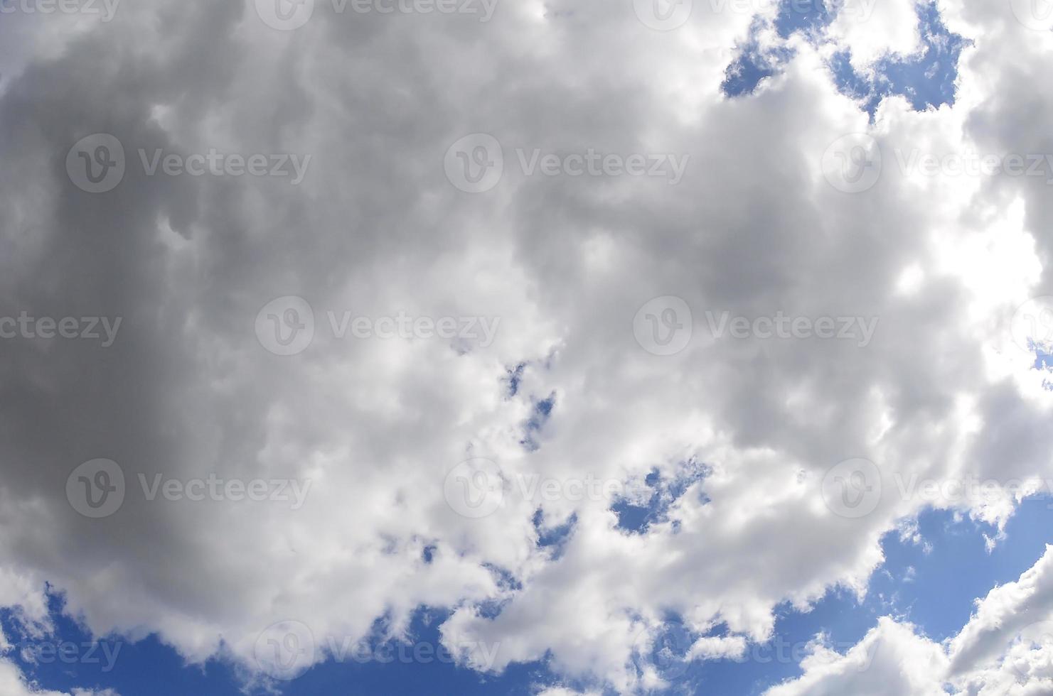 A blue sky with lots of white clouds of different sizes. Fisheye photo