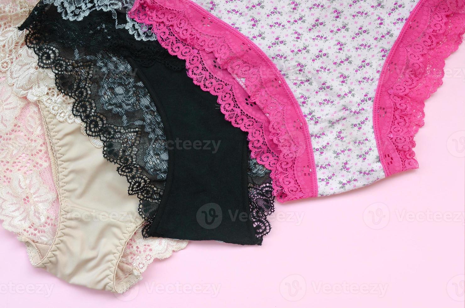 White, black and pink women underwear with lace on pink background with copy space. Advertising for shop of beautiful and comfortable women underwear photo