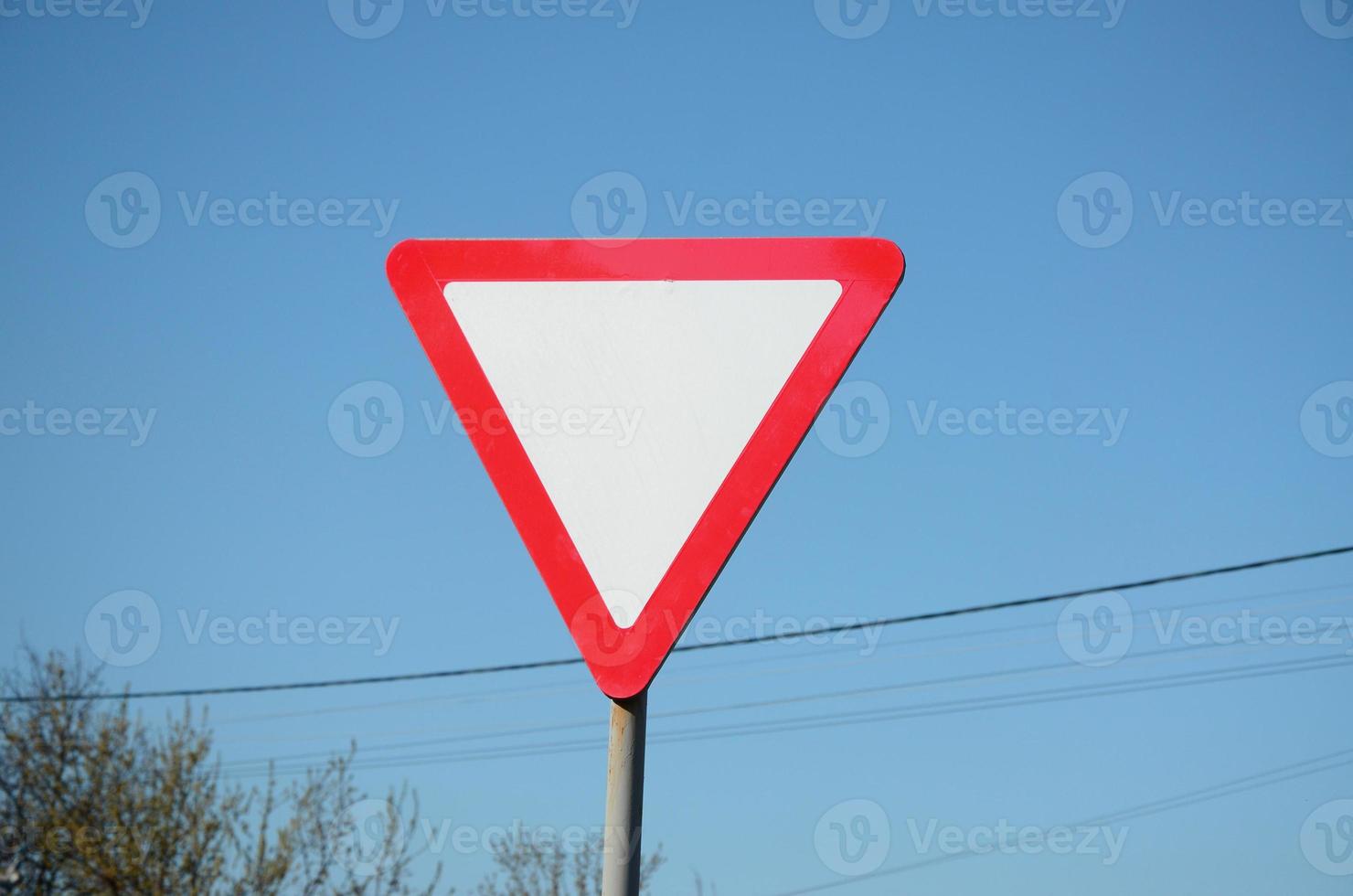 Traffic sign in the form of a white triangle. Give way photo