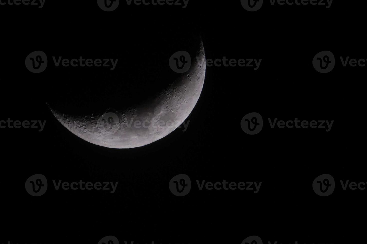 Crescent moon in dark winter sky with black background photo