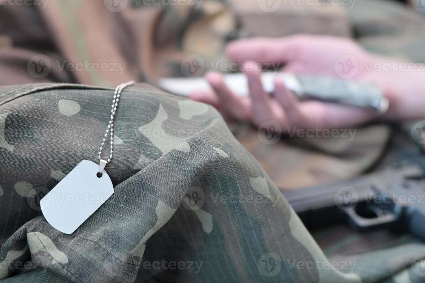 el símbolo vacío del ejército de un soldado militar muerto yace sobre ropa de camuflaje. suicidio durante el servicio militar en el ejército ruso foto