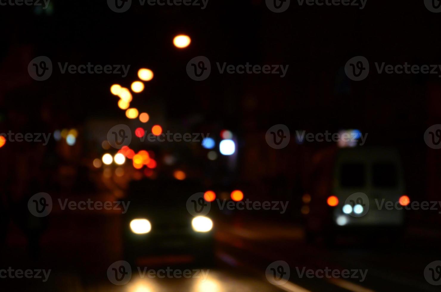 Blurred night scene of traffic on the roadway. Defocused image of cars traveling with luminous headlights. Bokeh Art photo