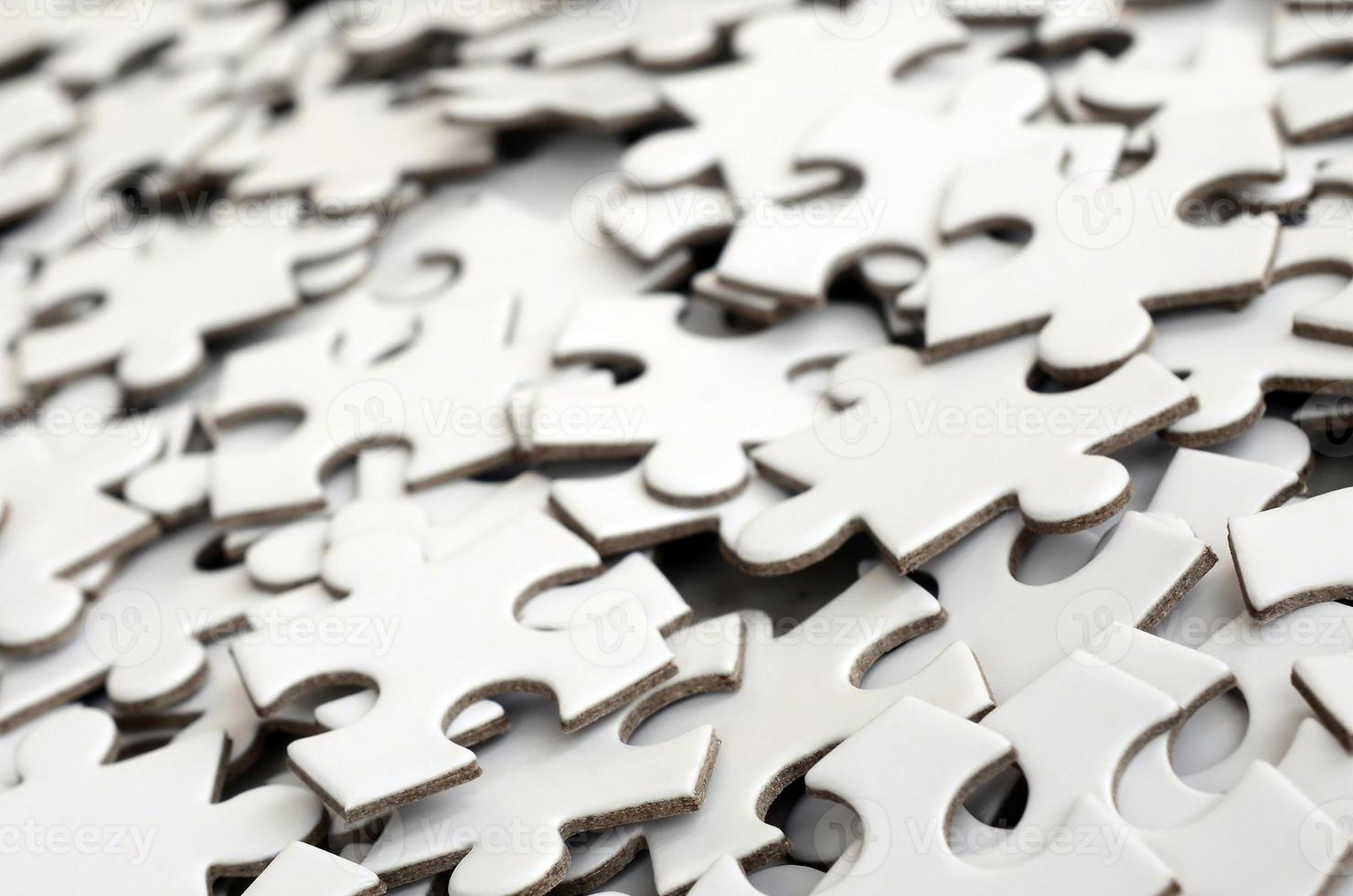 Close-up of a pile of uncompleted elements of a white puzzle. A huge number of rectangular pieces from one large white mosaic photo