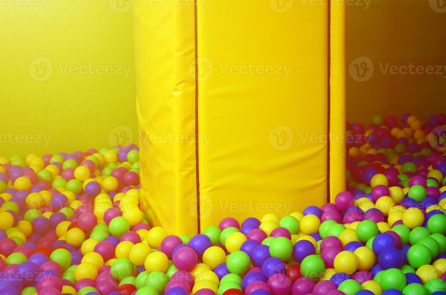 Many colorful plastic balls in a kids' ballpit at a playground photo