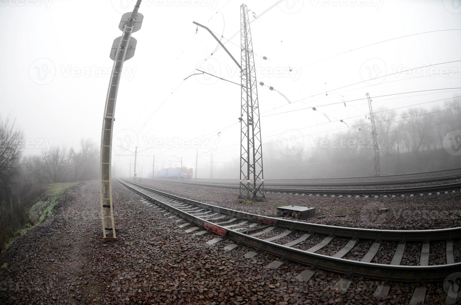 el tren suburbano ucraniano corre a lo largo del ferrocarril en una mañana brumosa. foto de ojo de pez con mayor distorsión