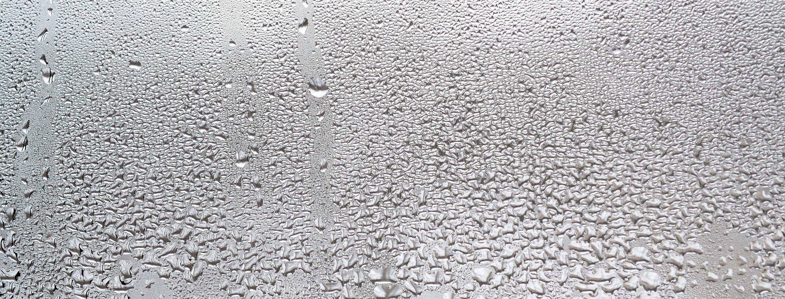 Texture of a drop of rain on a glass wet transparent background. Toned in grey color photo
